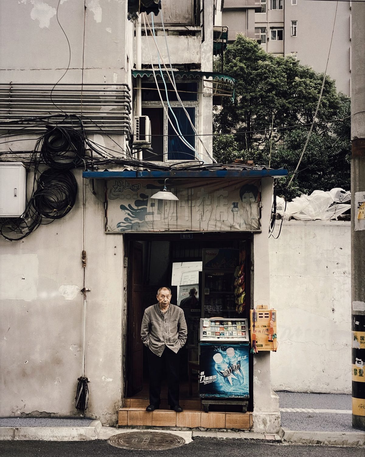 实体老板站在城市街边的自家店铺门前