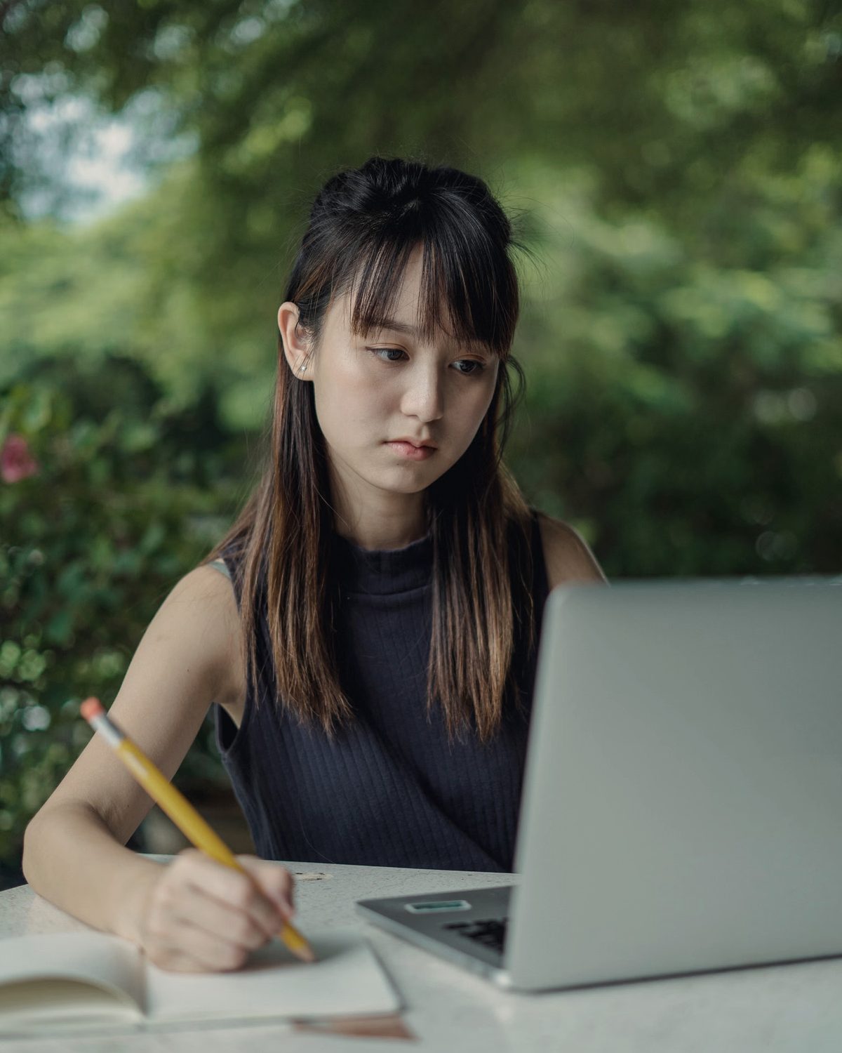 学生坐在桌前专注看着笔电学习