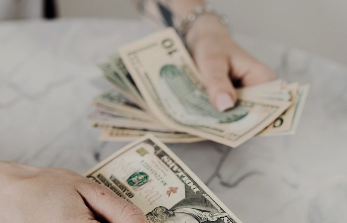 手上清点数叠现金，象征广告投流无底洞式的消耗